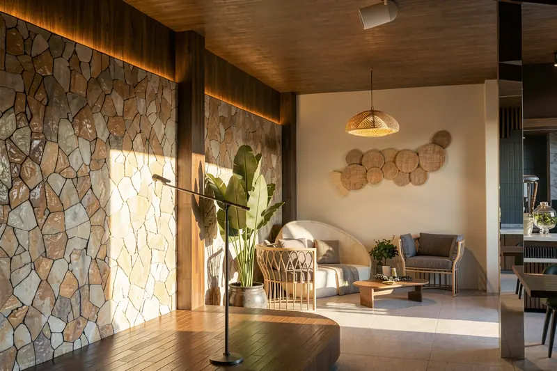 Lounge com parede em pedra natural, forro de madeira e fibras naturais